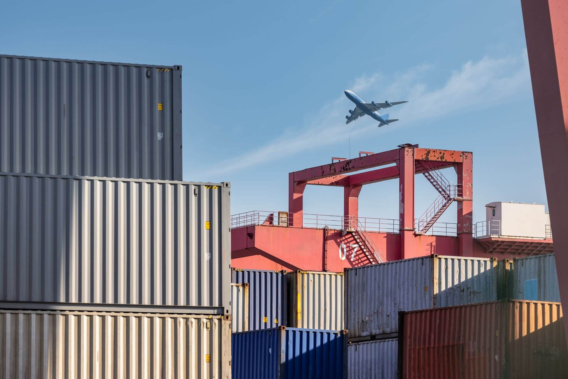 container yard closeup with airplane in sky 2025 01 29 07 38 20 utc